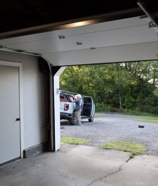 Bear Door Services team installing a garage door with service truck outside