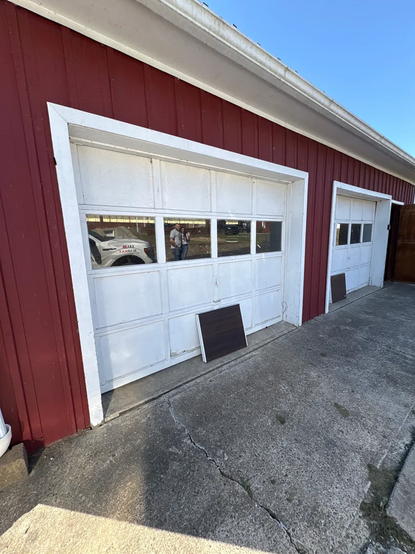 Frank Wise garage before — Faded white doors on a red barn, reborn as rich woodgrain CHI carriage doors.