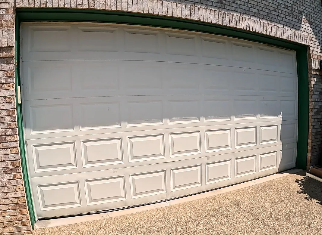 Kristi Evans garage before — Dated doors replaced with woodgrain CHI doors and crisp new brown trim.