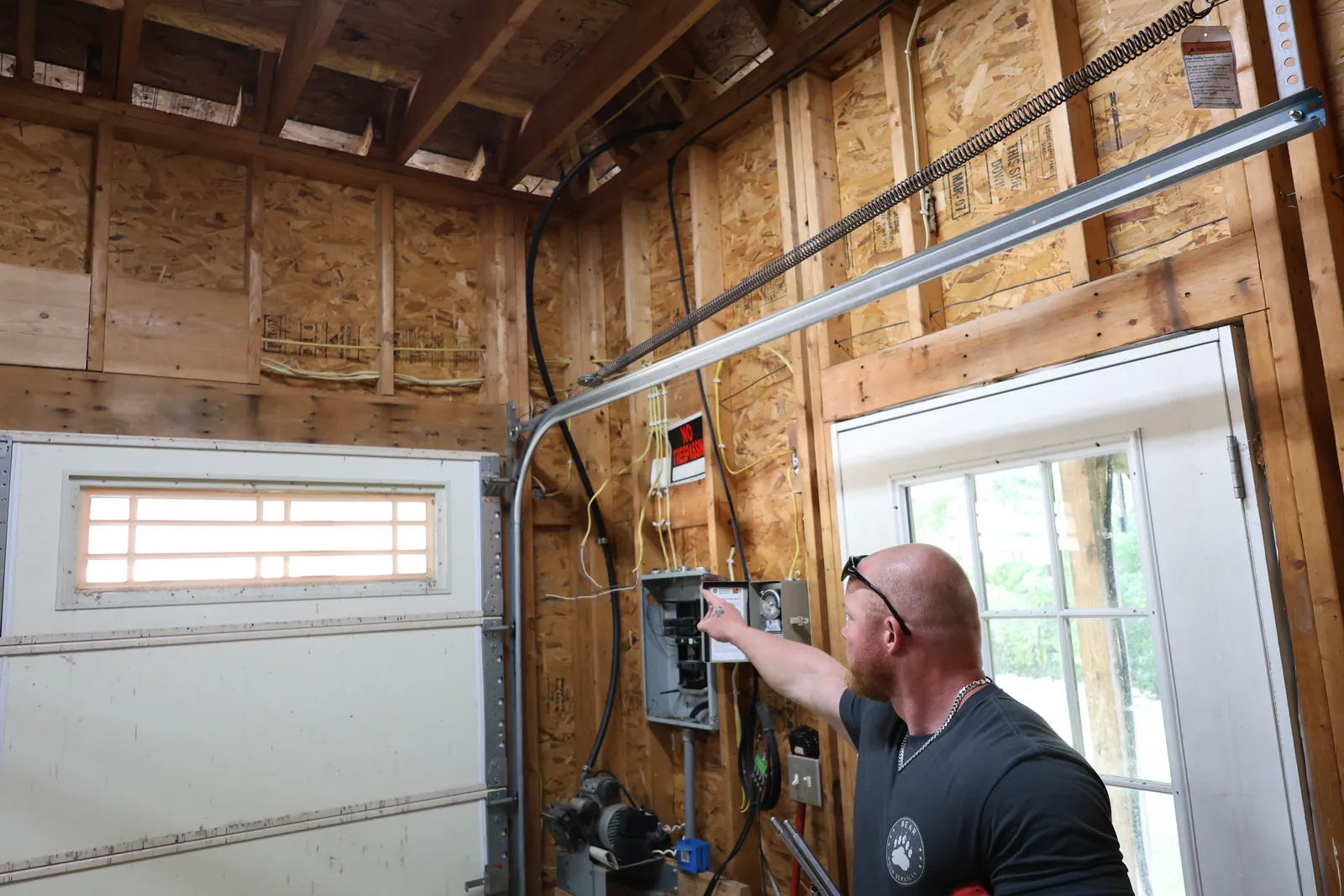 Steve garage before — An aged paneled door reborn as a modern full-view aluminum & glass door.