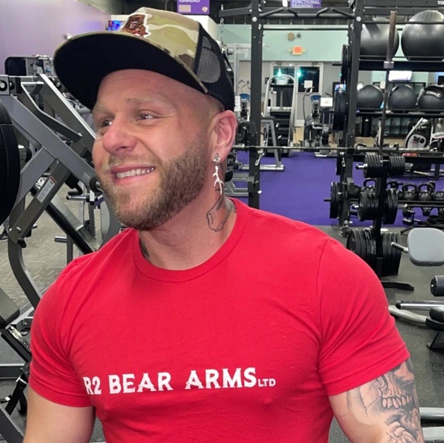 The owner of Bear Door Services wearing a company branded T-shirt while at a gym, representing the active and robust nature of the company's leadership.